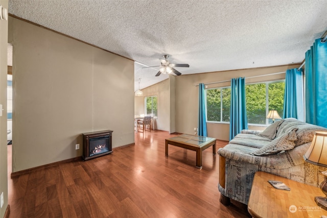 living room featuring hardwood / wood-style flooring, ceiling fan, lofted ceiling, and a textured ceiling