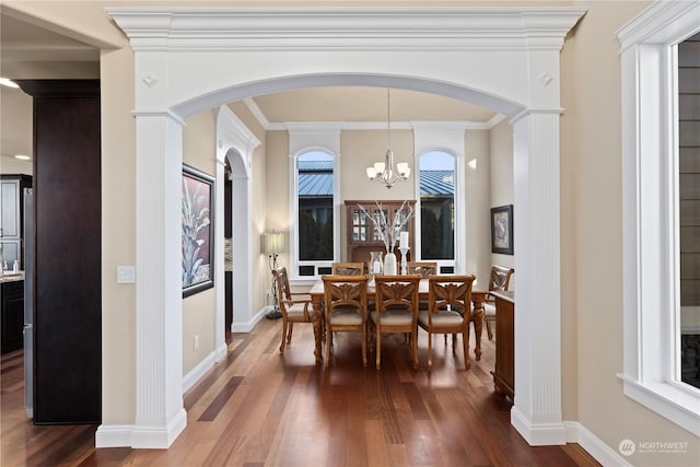 dining space featuring hardwood / wood-style flooring, ornamental molding, and a notable chandelier