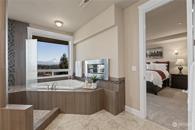 bathroom featuring a mountain view and tiled bath