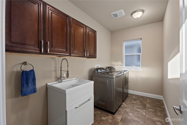 laundry area with washing machine and dryer and cabinets