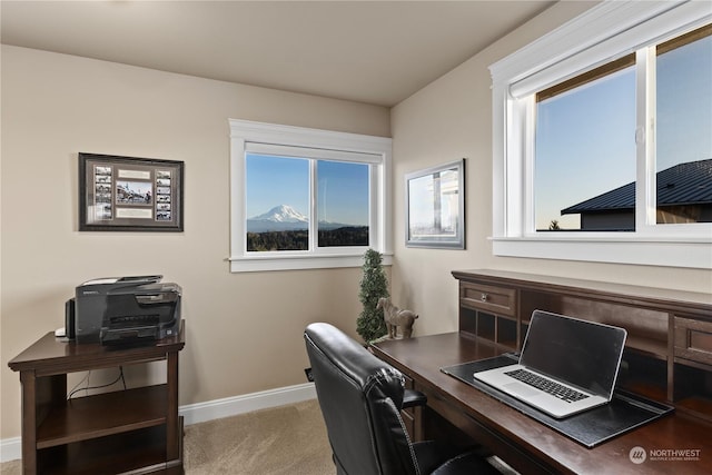 office featuring a wealth of natural light, a mountain view, and light carpet