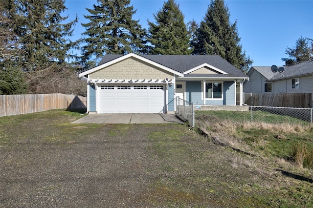 single story home with a fenced front yard, a front yard, driveway, and an attached garage