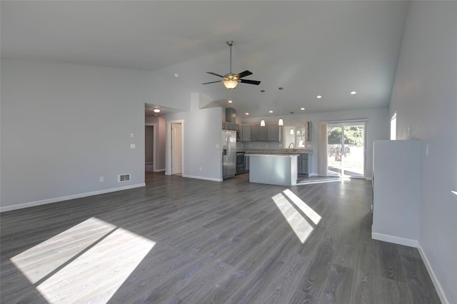 unfurnished living room with a ceiling fan, dark wood-style flooring, visible vents, and baseboards