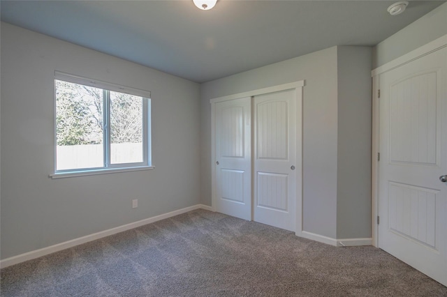 unfurnished bedroom featuring a closet, carpet flooring, and baseboards