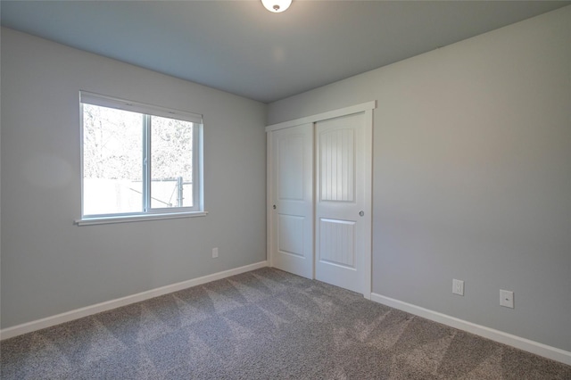 unfurnished bedroom featuring a closet, baseboards, and carpet flooring