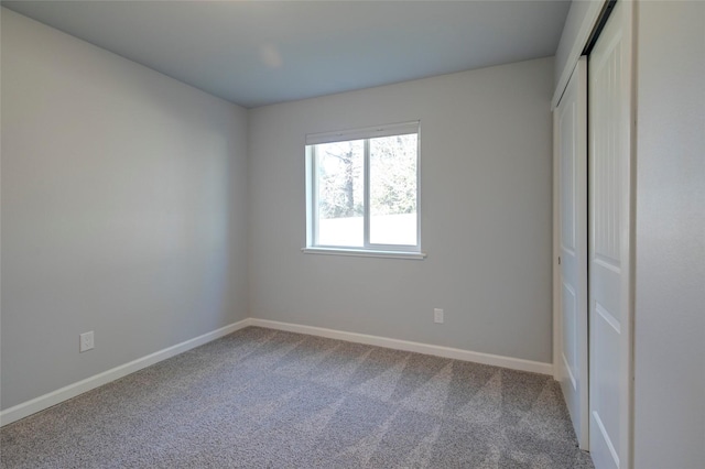 unfurnished bedroom featuring a closet, carpet flooring, and baseboards