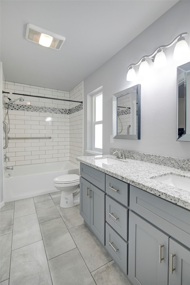 full bathroom featuring toilet, washtub / shower combination, a sink, and visible vents