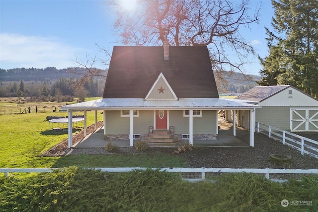 view of front of house with a front yard and a rural view