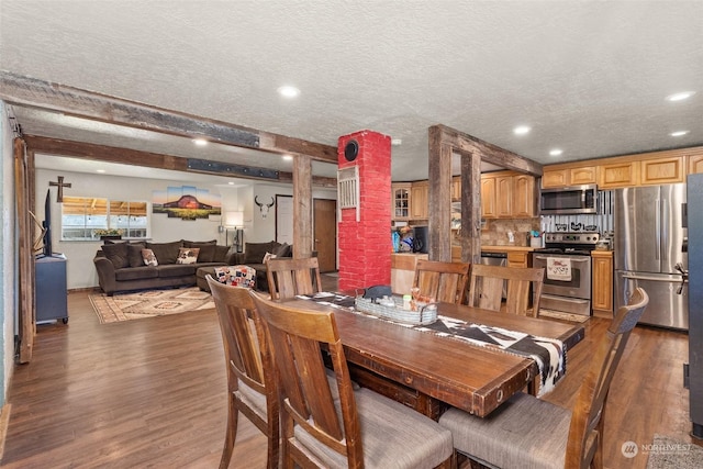 dining space featuring a textured ceiling, dark hardwood / wood-style flooring, and beam ceiling