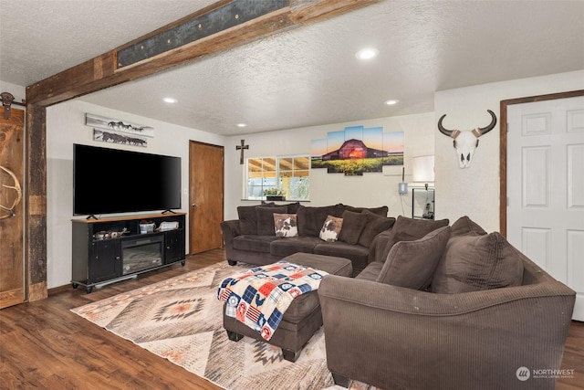 living room with a fireplace, dark hardwood / wood-style floors, and a textured ceiling