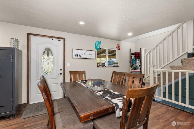 dining space featuring dark hardwood / wood-style floors and a textured ceiling