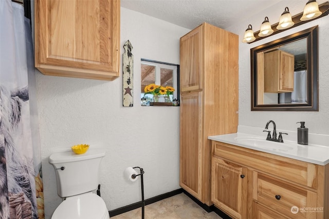 bathroom featuring a textured ceiling, toilet, and vanity