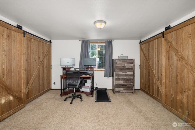 office area featuring carpet flooring and a barn door