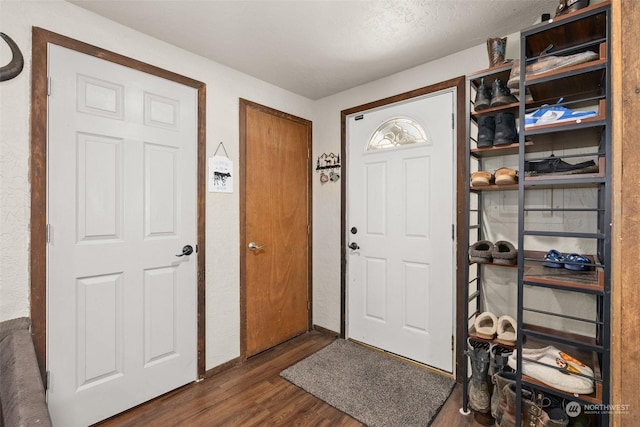 entrance foyer with dark wood-type flooring and a textured ceiling