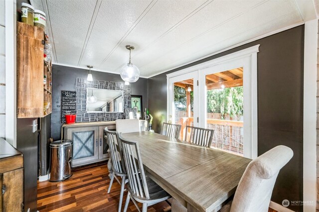 dining area with a textured ceiling and dark wood-type flooring