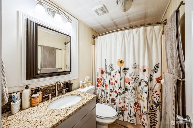 bathroom featuring walk in shower, vanity, and toilet