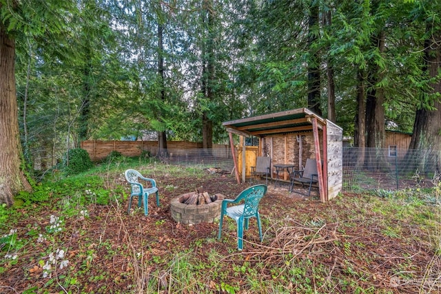 view of yard with an outdoor fire pit and an outdoor structure