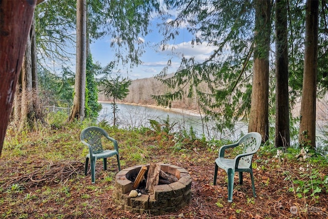 view of property's community featuring a fire pit and a water view