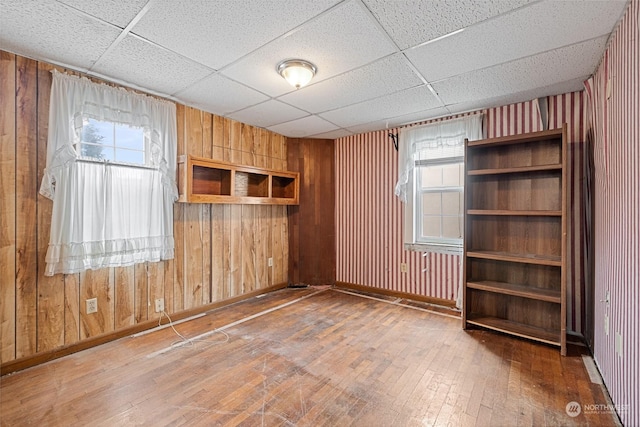 unfurnished room featuring a drop ceiling and wood-type flooring