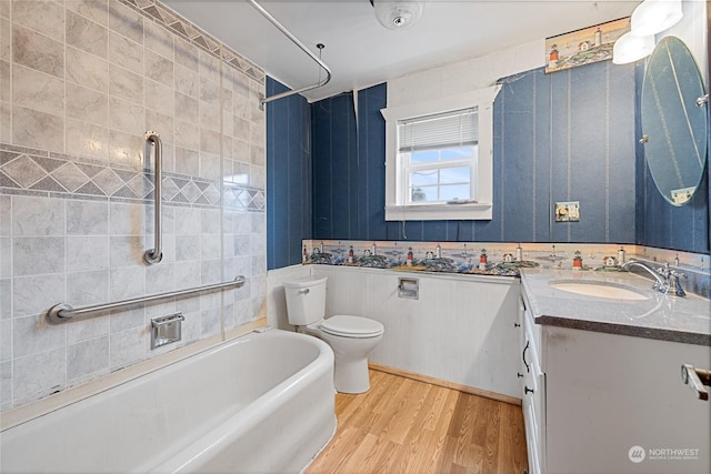 full bathroom featuring washtub / shower combination, toilet, vanity, and wood-type flooring