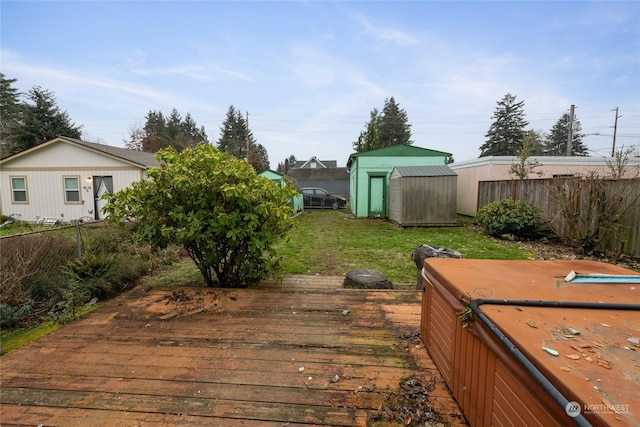 wooden deck featuring a hot tub and a storage shed