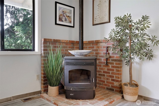 details with a wood stove, baseboards, and visible vents