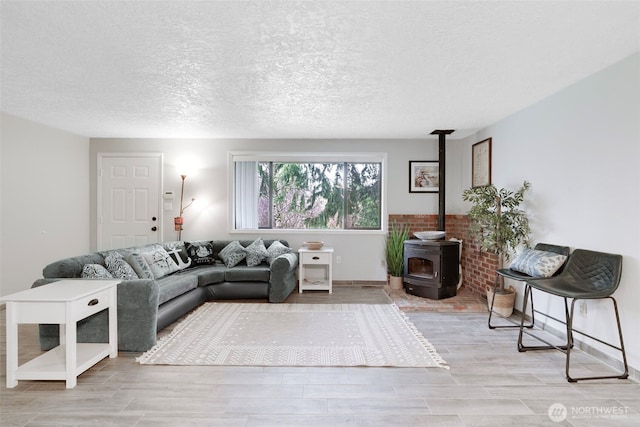 living area featuring a textured ceiling, wood finish floors, and a wood stove