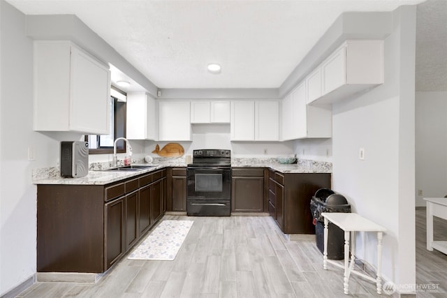 kitchen featuring dark brown cabinets, black range with electric cooktop, a sink, and white cabinets