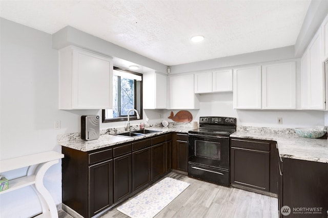 kitchen featuring dark brown cabinetry, electric range, white cabinetry, and a sink