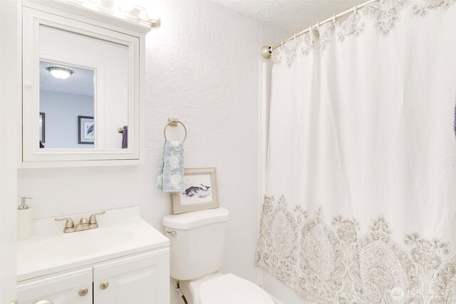 bathroom featuring toilet, a shower with shower curtain, a textured ceiling, and vanity