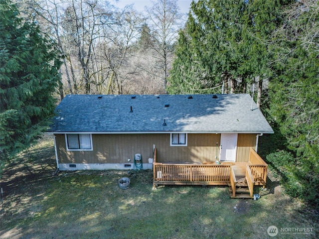 back of house with crawl space, a shingled roof, a deck, and a yard