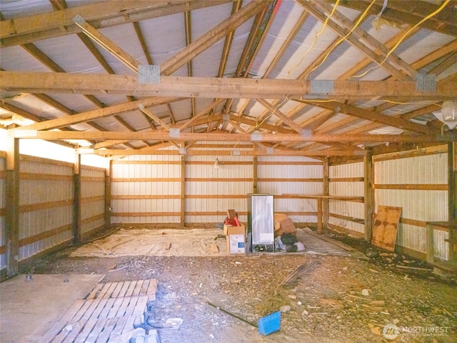 miscellaneous room featuring vaulted ceiling and metal wall