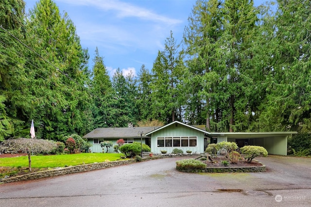 single story home with a front yard and a carport