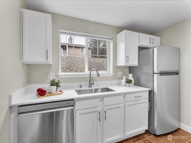 kitchen with white cabinets, tile patterned flooring, appliances with stainless steel finishes, and sink