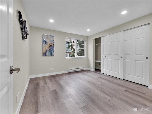 unfurnished bedroom with a baseboard radiator, light hardwood / wood-style flooring, and a closet