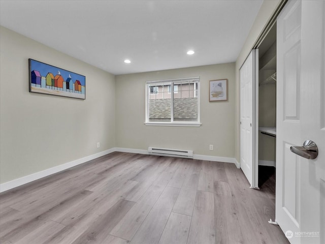 unfurnished bedroom with a baseboard radiator, a closet, and light wood-type flooring