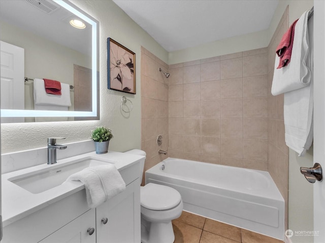 full bathroom featuring toilet, tiled shower / bath combo, tile patterned flooring, and vanity