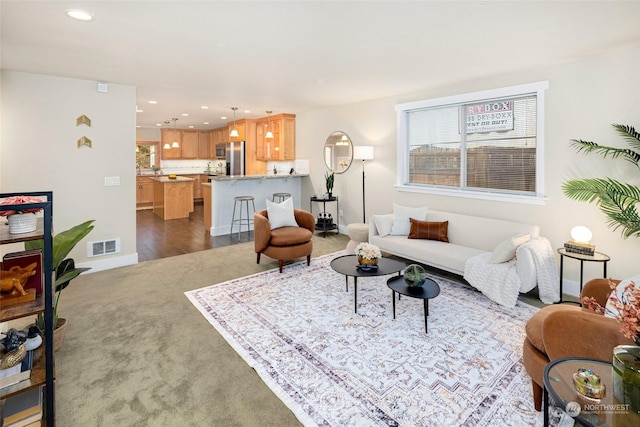 living room featuring a wealth of natural light and dark colored carpet