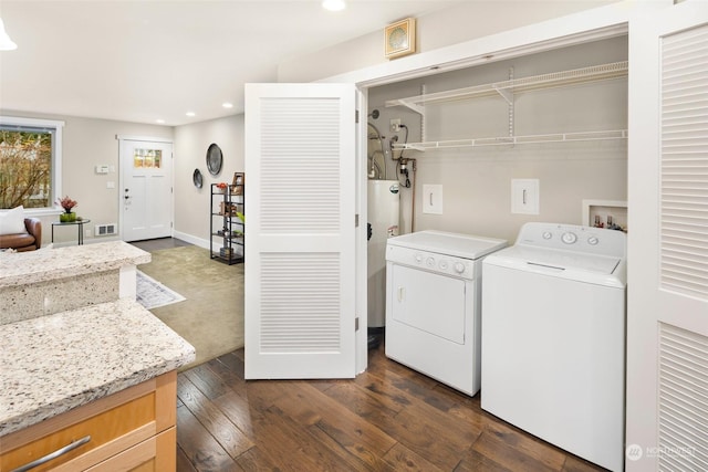 laundry room featuring water heater, independent washer and dryer, and dark hardwood / wood-style floors