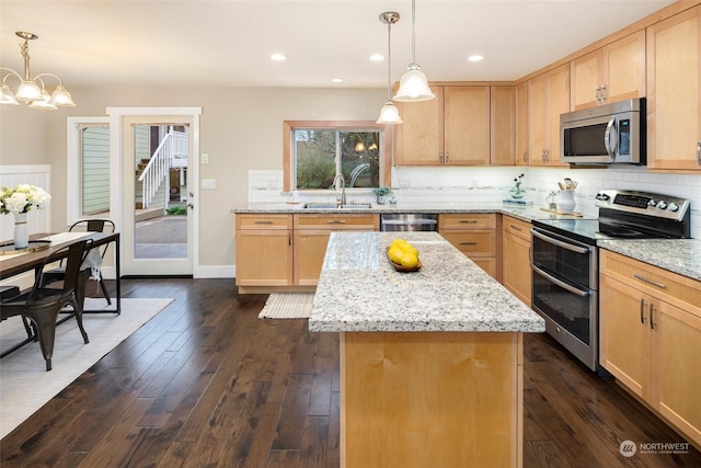 kitchen featuring a kitchen island, pendant lighting, sink, dark wood-type flooring, and appliances with stainless steel finishes