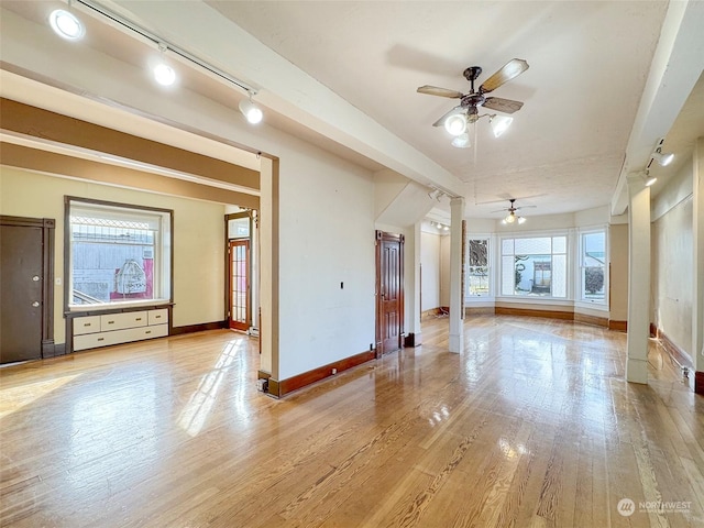 unfurnished living room featuring track lighting, ornate columns, ceiling fan, and light wood-type flooring