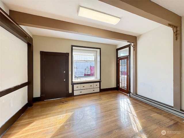 spare room with a baseboard heating unit and light hardwood / wood-style flooring