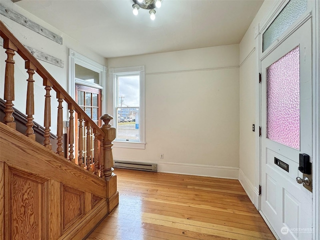 foyer entrance with light hardwood / wood-style flooring and baseboard heating