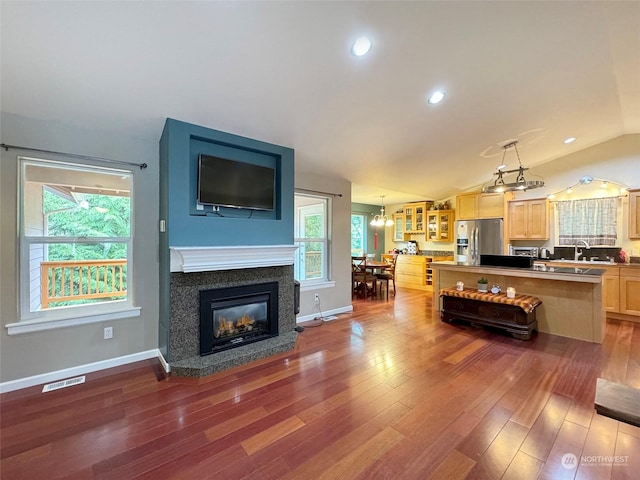 living room with sink, an inviting chandelier, lofted ceiling, and dark hardwood / wood-style floors