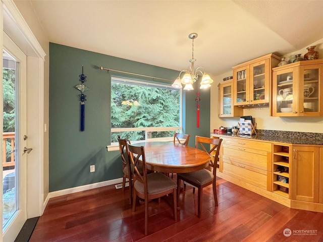 dining space with vaulted ceiling, dark hardwood / wood-style flooring, a healthy amount of sunlight, and a notable chandelier