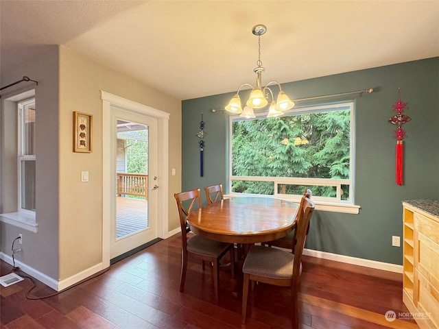 dining area with a chandelier and dark hardwood / wood-style floors