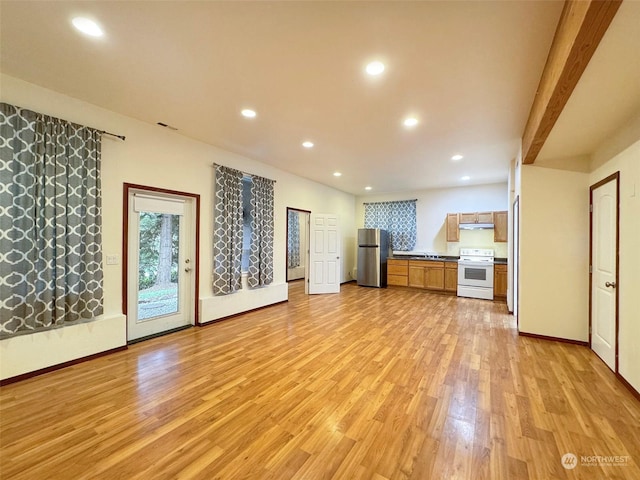 unfurnished living room with light wood-type flooring and beam ceiling