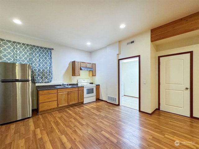 kitchen featuring stainless steel refrigerator, white electric range oven, light hardwood / wood-style flooring, and sink