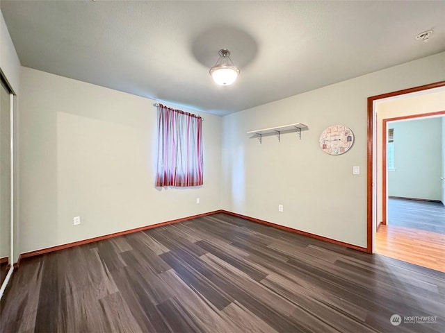 spare room featuring dark wood-type flooring