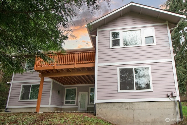 back house at dusk with a balcony